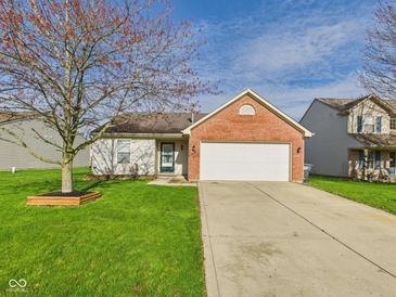 Charming single-story home featuring a brick facade, attached garage, and well-maintained lawn at 6233 Boulder Dr, Anderson, IN 46013