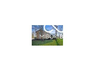 Charming home with a stone facade, mature trees, and lush green lawn offering great curb appeal at 8500 N Ravenwood Dr, Muncie, IN 47303