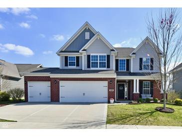 Charming two-story home with a manicured lawn, a brick and vinyl facade, and a three-car garage at 1291 Timber Bluff Rd, Westfield, IN 46074