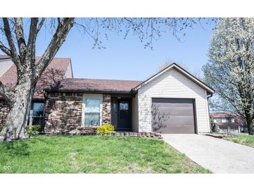 Charming home with a brick facade, mature trees, a well-manicured lawn, and an attached garage at 562 Monte Vista Dr, Greenwood, IN 46143