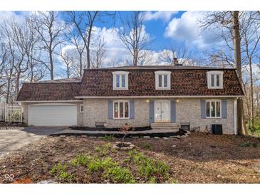 Charming stone home featuring a unique roof and a spacious two-car garage at 5917 Camelback Ct, Indianapolis, IN 46250