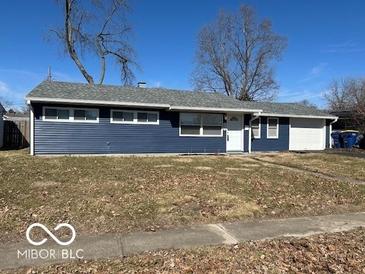 Charming single-story home with blue siding, a white door, and an attached garage on a sunny day at 6642 E 47Th St, Indianapolis, IN 46226