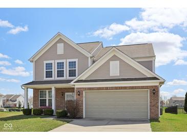 Charming two-story home with brick and vinyl siding, complemented by a well-manicured lawn at 6681 Keepsake Dr, Whitestown, IN 46075