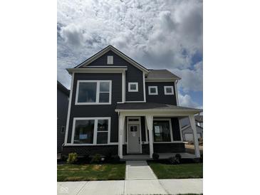 Charming two-story home with dark siding, a covered porch, and large windows showcasing its inviting facade at 799 Rose Garden Way, Westfield, IN 46074