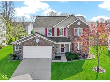 Charming two-story home featuring a well-maintained lawn, brick accents, and attractive red shutters at 11741 Langham Crescent Ct, Fishers, IN 46037