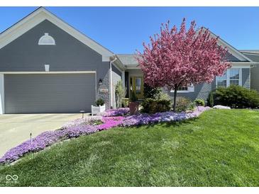 Charming home with a well-manicured lawn, flowerbeds, and a beautiful flowering tree at 14019 Colville Cir, Carmel, IN 46033