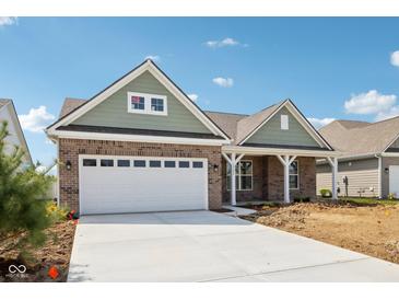 Charming brick home featuring a two-car garage and covered porch, set under a bright blue sky at 19245 Red Willow Ln, Noblesville, IN 46062