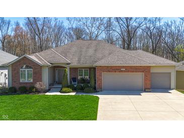 Beautiful brick home with a well-manicured lawn, attached garage, and a charming front porch at 267 Westbrook Ct, Columbus, IN 47201