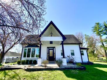 Charming two-story home with black and white trim, landscaped yard, and a clear blue sky at 4029 W Fairview Rd, Greenwood, IN 46142