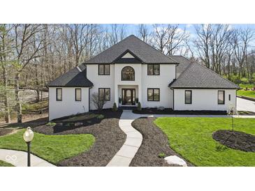 Stunning two-story home with black and white accents, lush lawn, and beautiful landscaping at 4312 S Woodbridge Ln, New Palestine, IN 46163