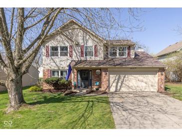 Charming two-story home featuring vinyl siding, a well-manicured lawn, and an attached two-car garage at 6018 Maple Forge Cir, Indianapolis, IN 46254