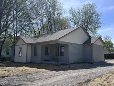 Charming single-story home with light blue siding and a well-maintained gravel driveway at 609 W Pearl St, Trafalgar, IN 46181