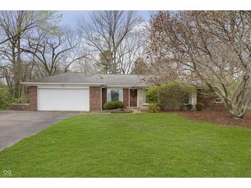 Charming single-story brick home with a well-manicured lawn and mature trees at 7026 Spring Mill Rd, Indianapolis, IN 46260
