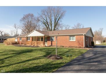 Charming brick home with a covered front porch and well-maintained lawn at 7260 Marla Dr, Indianapolis, IN 46256