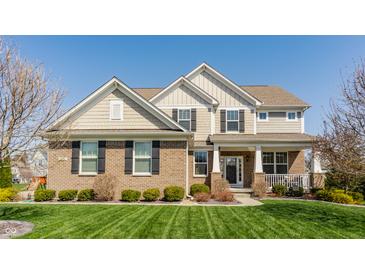 Charming two-story home featuring a brick facade, complemented by a well-manicured lawn and established landscaping at 8855 Sugar Cay Ct, Zionsville, IN 46077