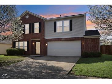 Charming two-story home with brick and siding, attached two-car garage, and driveway at 10303 Memorial Knoll Dr, Indianapolis, IN 46234