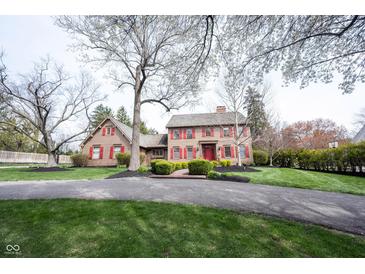 Charming two-story home with red shutters, a brick walkway and a well-manicured lawn at 13599 Brentwood Ln, Carmel, IN 46033