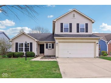 Charming two-story home featuring a two car garage, well maintained lawn and dark shutters against neutral siding at 13847 Wabash Dr, Fishers, IN 46038
