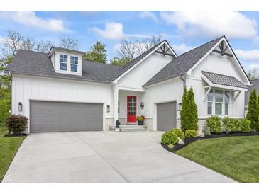 Charming home with a two-car garage, red door, and a beautifully landscaped front yard at 16422 Brigham Ln, Westfield, IN 46074