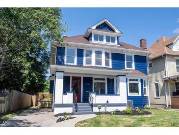 Inviting two-story home with a blue exterior, red front door, and landscaped front yard at 2226 N Capitol Ave, Indianapolis, IN 46208