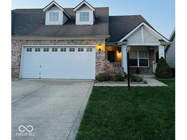 Charming brick home featuring a manicured lawn and a convenient two-car garage at 4871 Franklin Villas Dr, Indianapolis, IN 46237
