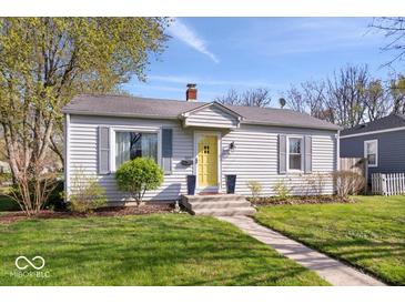 Charming single-story home featuring a well-maintained lawn, inviting yellow front door and blue shutters at 5277 Kingsley Dr, Indianapolis, IN 46220