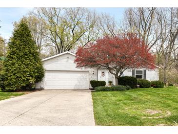 Charming single-story home featuring a well-maintained lawn, flowering tree, and attached two-car garage at 7145 Lafayette Rd, Indianapolis, IN 46278