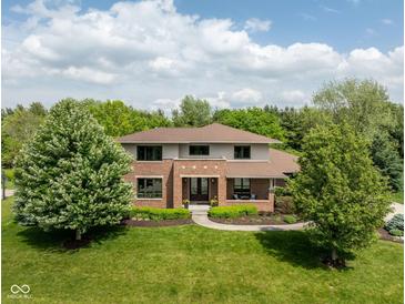 Aerial view of a two story brick home with mature landscaping, large front yard, and a charming walkway leading to the front door at 13225 Gatman Ct, Carmel, IN 46032