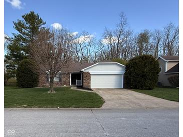Charming single-story brick home featuring an attached two-car garage and well-maintained landscaping at 1348 Secretariat Ln, Indianapolis, IN 46217