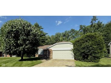 Lovely single-story home featuring a brick facade, attached garage, and a beautifully landscaped front yard at 1348 Secretariat Ln, Indianapolis, IN 46217