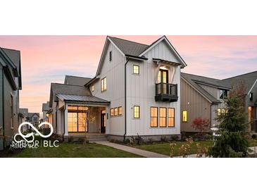 Beautiful two-story white home with black trim and a balcony at sunset at 17354 Ditch Rd, Westfield, IN 46074