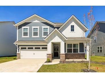 Charming two-story home showcasing a blend of blue and white siding with well-manicured lawn and a two car garage at 2250 Egbert Rd, Westfield, IN 46074