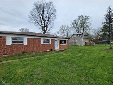 Charming single-story home with a classic brick facade and spacious front yard on a cloudy day at 314 S Taft Ave, Indianapolis, IN 46241