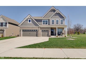 Charming two-story home with a three car garage, gray siding, brick accents and a well-manicured lawn at 4140 Omaha Dr, Bargersville, IN 46106