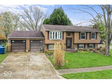 Traditional two-story home with a two-car garage, inviting curb appeal, and well-maintained landscaping at 6853 Cordova Dr, Indianapolis, IN 46221