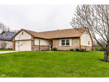 Charming brick and vinyl home featuring a well-manicured lawn and attached two car garage at 8973 Sunningdale Blvd, Indianapolis, IN 46234