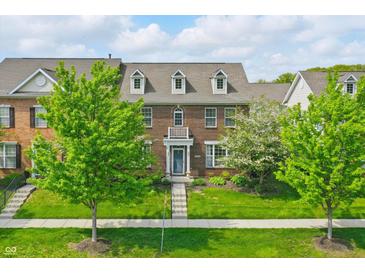 Charming brick townhouse with a well-manicured lawn and inviting front entrance with balcony at 13510 E 131St St, Fishers, IN 46037