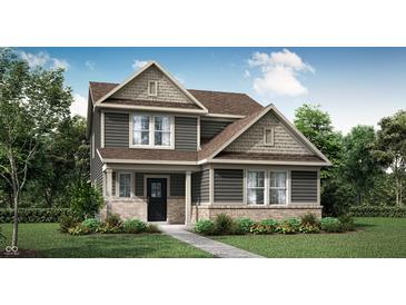 Charming two-story home with stone accents, a well-manicured lawn, and professionally landscaped shrubbery at 15379 Alperton Rd, Fishers, IN 46037