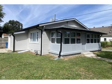 Charming single-story home featuring vinyl siding, a well-maintained lawn and a covered porch with ample windows at 1546 Kappes St, Indianapolis, IN 46221