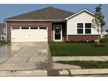 Inviting single-Gathering home featuring a manicured lawn, brick accents, and a two-car garage at 2212 Foothill Dr, Greenfield, IN 46140