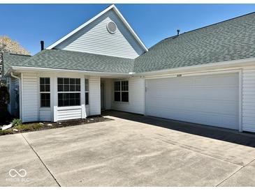 Charming white home featuring an attached two-car garage, and a well-kept lawn on a sunny day at 5129 W Preakness Ct, Muncie, IN 47304