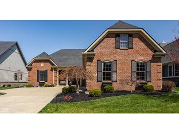 Beautiful brick home with manicured lawn, tasteful landscaping and black shutters at 528 Dylan Dr, Carmel, IN 46032