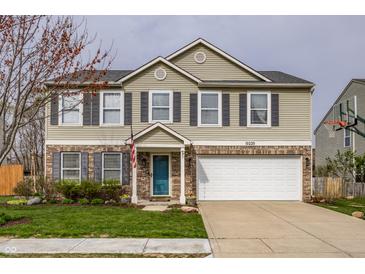Charming two-story home boasts a well-maintained lawn, attached two-car garage, and a welcoming blue front door at 10220 Tournon Dr, Fishers, IN 46037