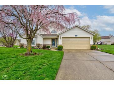 Charming single-story home featuring well-manicured lawn and beautiful flowering tree in a suburban setting at 118 Presidential Ct, Greenfield, IN 46140