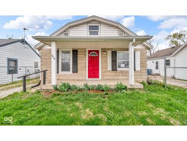 Charming home featuring a red front door, stone accents, and a covered porch at 4618 W Beecher St, Indianapolis, IN 46241
