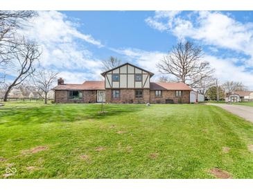 Charming two-story home with brick facade and expansive green lawn under a partly cloudy sky at 4930 Founders Ct, Anderson, IN 46017