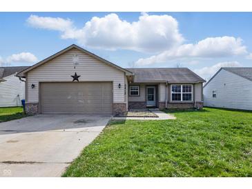 Charming single-story home featuring a two-car garage, inviting entrance and well-maintained lawn at 5213 Milhouse Rd, Indianapolis, IN 46221