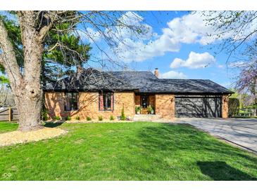 Charming brick home with an attached garage, mature tree, and beautifully landscaped front yard at 601 Ridge Rd, Greenwood, IN 46142