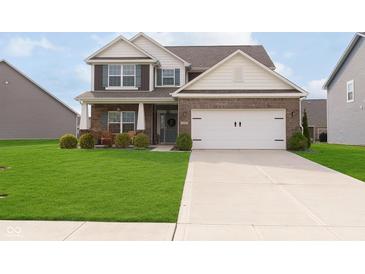 Charming two-story home with a well-manicured lawn and a two-car garage at 6156 N Cedarwood Dr, McCordsville, IN 46055