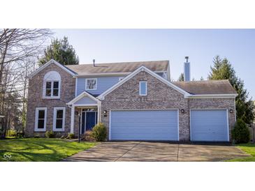 Charming two-story home with brick and light blue siding, a well-manicured lawn, and an attached two-car garage at 6967 Bluffridge Way, Indianapolis, IN 46278